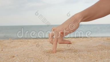女人的手指<strong>在</strong>沙滩<strong>上</strong>行走，<strong>在</strong>大海的背景下模仿男人的步态，手舞足蹈，<strong>在</strong>沙滩<strong>上玩耍</strong>，赋